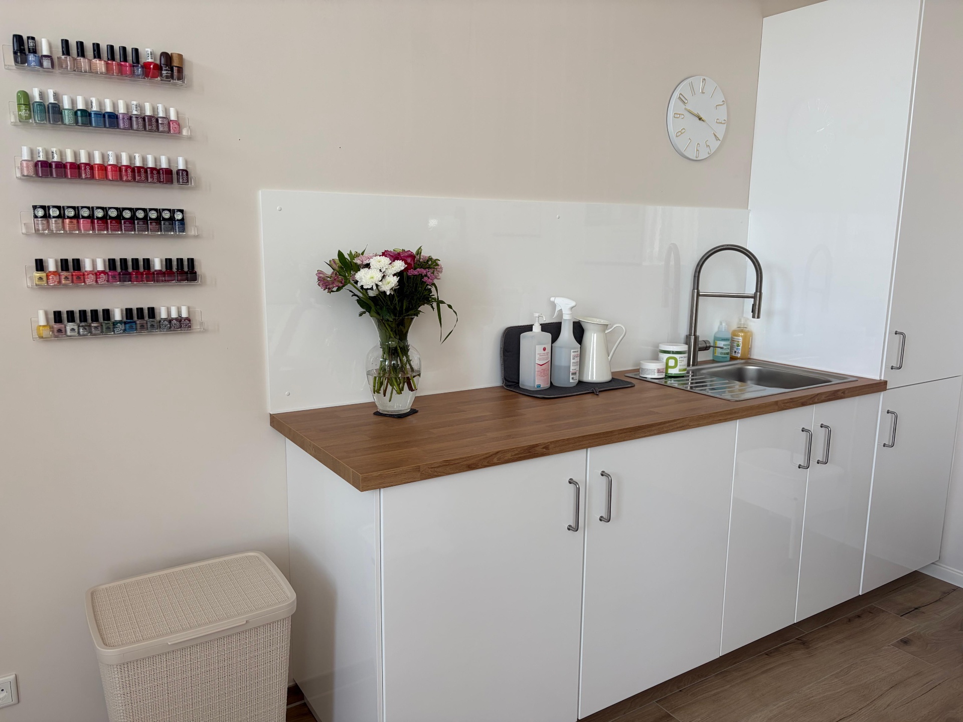 Pflegebereich mit Nagellack-Auswahl und frischen Blumen im Studio